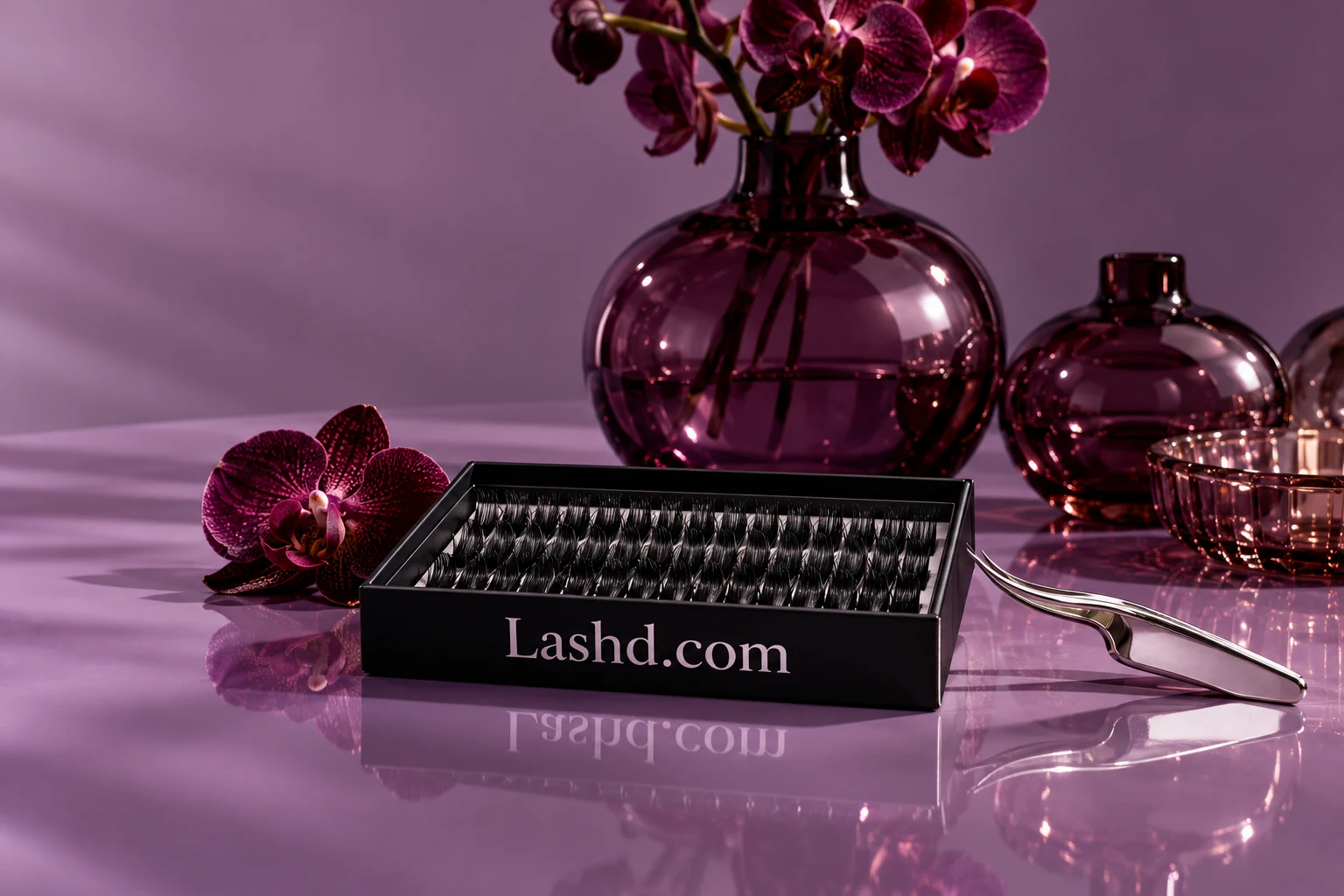 Plum glass and lash packaging carrying Lashd.com